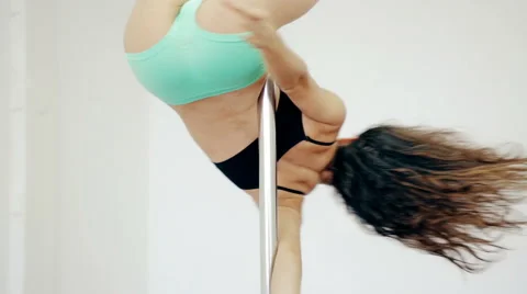 Medium shot Young girl dancing poledance in white room Stock Footage 65485093