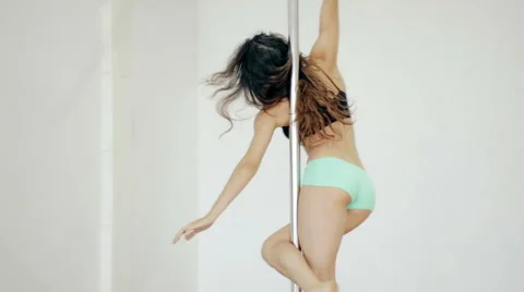 Medium shot Young girl dancing poledance in white room Stock Footage 65492279