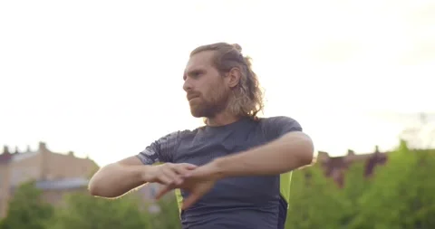 Medium shot of young guy doing sports warm-up in park Stock Footage 157973756