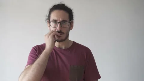 Medium shot of young man anxious biting his nails and looking at the camera Stock Footage 161551847