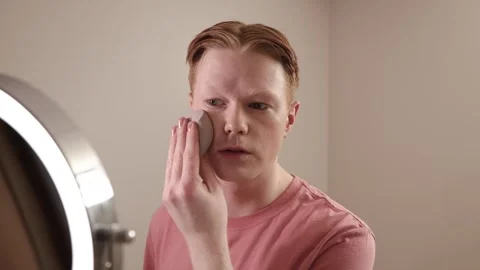 A Medium Shot Of A Young Man Applying Foundation Skincare Makeup Routine Stock Footage 309350715