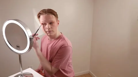 A Medium Shot of A Young Man Applying Eyeshadow in Front of Mirror Stock Footage 309976769