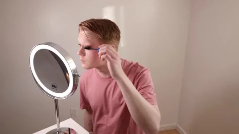 A Medium Shot of a Young Man Applying Mascara Makeup Routine Beauty Stock Footage 310035286