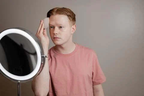 A Medium Shot Of A Young Man Applying Foundation Skincare Makeup Routine Stock Photos