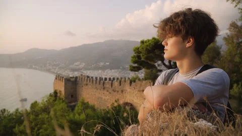 Medium shot of a young man looking at a view at sunset Stock Footage 142550446