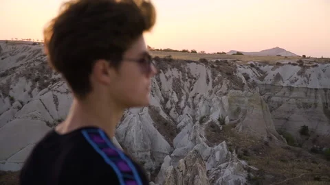 Medium shot of young man on mountain top overlooking view and sunset Stock Footage 142550041