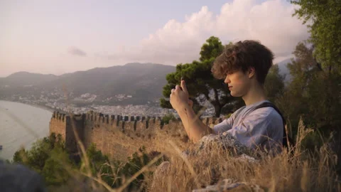 Medium shot of a young man using smartphone at sunset Stock Footage 142550467