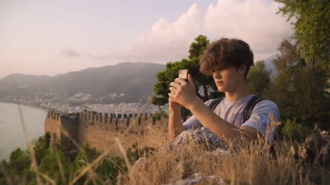 Medium shot of a young man using smartphone at sunset Stock Footage 142550483