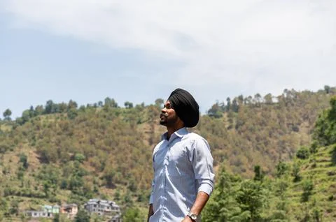Medium Shot of Young Sikh Man in Formal Attire Looking Up Posing in Mountai.. Stock Photos