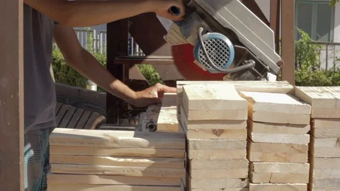 Medium Shot of Young Worker Cutting Wooden Boards with a Circular Saw Video stock 89771159
