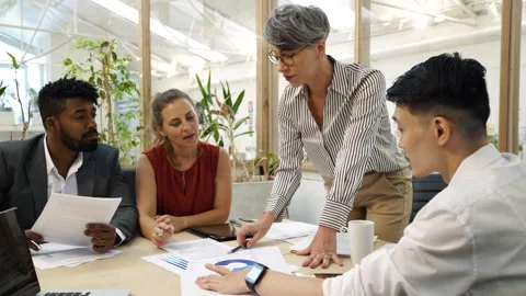 Medium side view shot of female company manager giving instructions to her staff Stock Footage 277956467