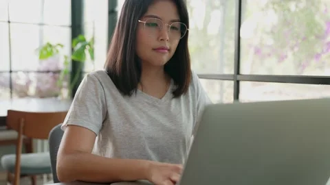 Medium side view shot of Young business woman sits in a cafe and works at a l 스톡 동영상 154696192