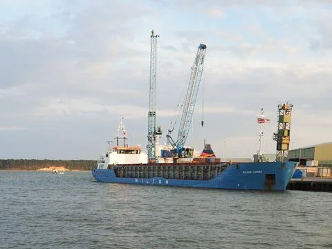 A medium size freighter ship seen being unloaded at Dockside Stock Photos