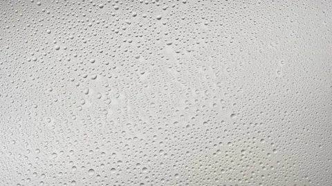 Medium size water drops blown off the glass surface on grey bg Stock Footage 171891493