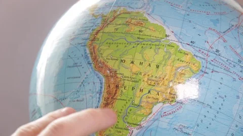 Medium-sized globe with human hands looking with a magnifying glass on a black Stock Footage 75187873