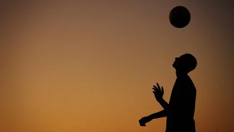 Medium sized photo capturing a silhouette of a teenager, young man playing with Stock Photos