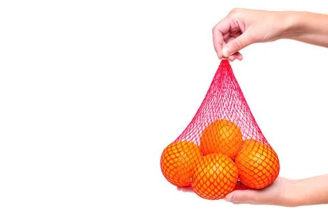 Medium-Sized Red Mesh Bag with Oranges in Hands Stockfoto's
