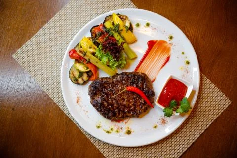 Medium-sized steak with vegetables in a cafe. Stock Photos