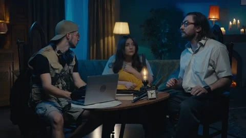 Medium-sized video capturing two ghost hunters and a victim sitting at the table Stock Footage 252381728