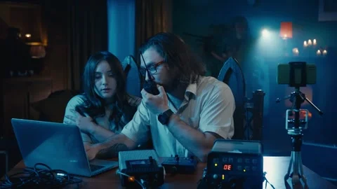 Medium-sized video of a ghost hunter and a victim sitting at the table in a dark Stock Footage 252382043