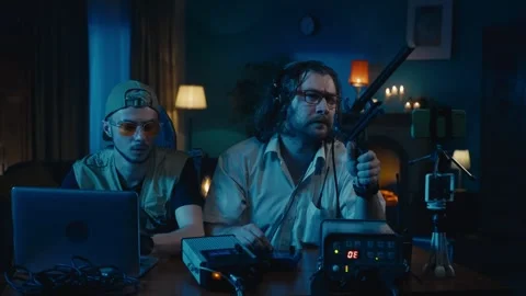 Medium-sized video of two ghost hunters sitting at the table in a dark room Stock Footage 252381841