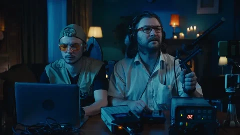 Medium-sized video of two ghost hunters sitting at the table in a dark room Stock Footage 252381963