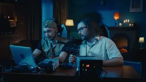 Medium-sized video of two ghost hunters sitting at the table in a dark room Stock Footage 252382114