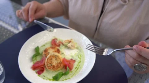 A  medium sized woman in peach fuzz dress eating cottage cheese pancakes wi.. Video stock 275157698