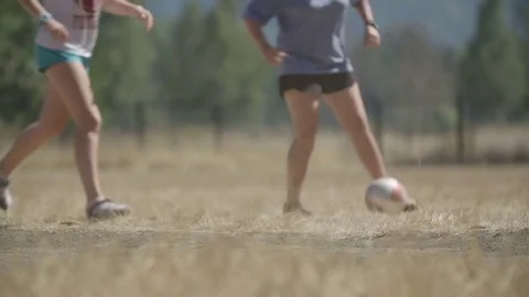 Medium Slow Motion Shot Of Kids Playing Soccer Football On A Dirt Lot Stock Footage 70379714