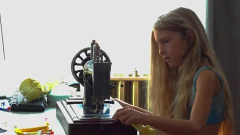 Medium Static Profile Shot of Young Girl Disassembling Vintage Sewing Machine Stock Footage 346802416