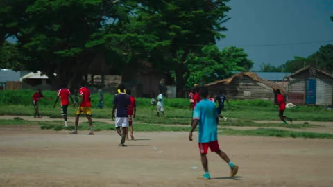 Medium tracking shot of boys playing football, Betou, Congo Vídeo Stock 338167530
