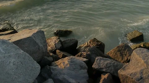 Medium view Large Rocks on edge of water shoreline near sunset in Florida. Multi Stock Footage 276676398