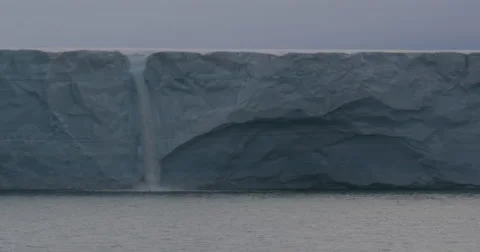 Medium Waterfall flowing into ocean over edge of glacier Stock Footage 61962202