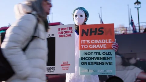 Medium wide shot of activist in mask protesting the assisted dying bill Vidéo 293843975