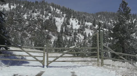 Medium wide shot of a locked gate on a snowy mountain road Stock Footage 47382222