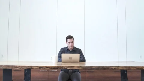 Medium wide shot of a man using a laptop Stock Footage 76235177
