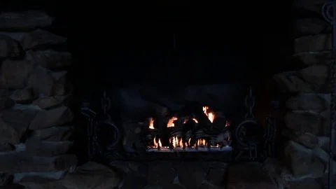 Medium wide shot of stone fireplace with fire burning Video stock 79549629