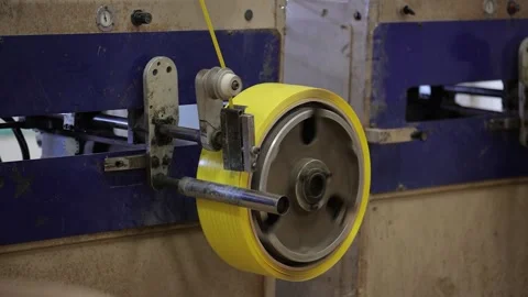 Medium wide shot of winding process of packaging strap in the machine Stock-Footage 306582080