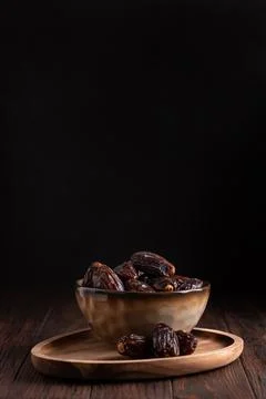 Medjoul Dates in Rustic Ceramic Bowl on Dark Wooden Background Stock Photos