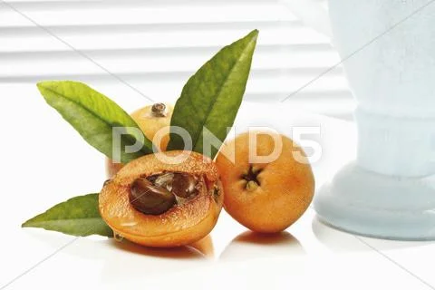 Medlars, whole and halved Stock Photos
