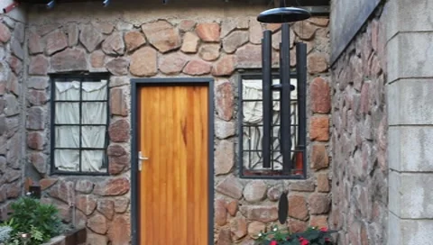 Medodious Wind Chimes in Front of Stone House (HD) Stock Footage 7131211