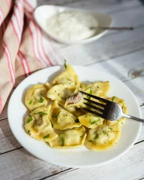 Meet dumplings served on a plate with a fork on a wooden table alongside a .. Fotos de archivo