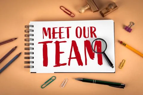 Meet Our Team Text on Notebook With Office Supplies and Magnifying Glass Foto stock