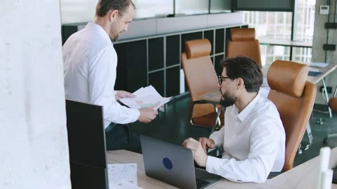 Meeting between two professionals discussing project details in a modern office Stock Footage 315781776