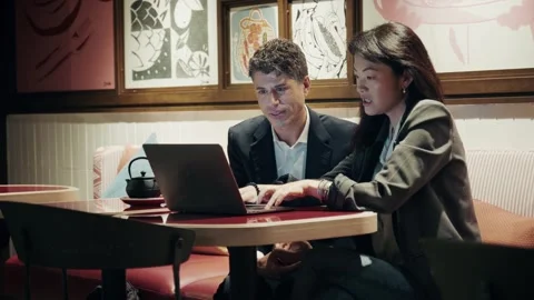 Meeting in a cafe where two professionals discuss ideas while using a laptop Stock-Footage 304539166