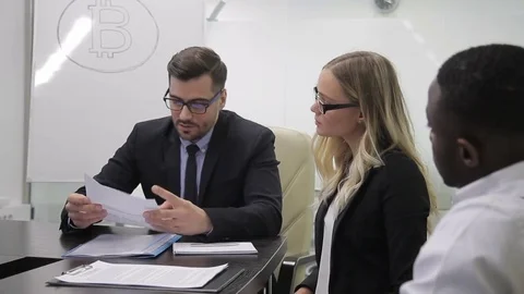At meeting group of multiethnic people study documents about bitcoin. Stock Footage 85329731