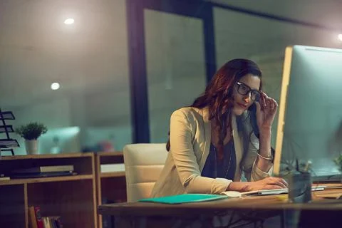 Meeting her commitments no matter the hour. a young businesswoman working late Foto stock