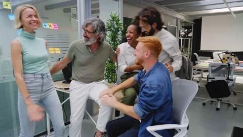 Meeting of a multiracial work team reacting with enthusiasm to a new Stock Footage 232897573