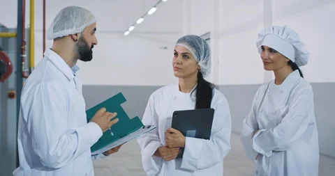 Meeting time between engineer and bakery workers in the big manufacturing Stock Footage 115639175