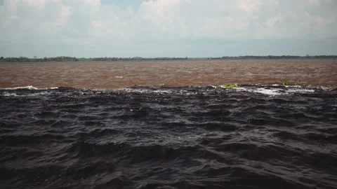 The Meeting of Waters (Encontro das Aguas) is the confluence between the Rio  Negro river, with dark water, and lighter  river or Rio Solimoes  Stock Photo